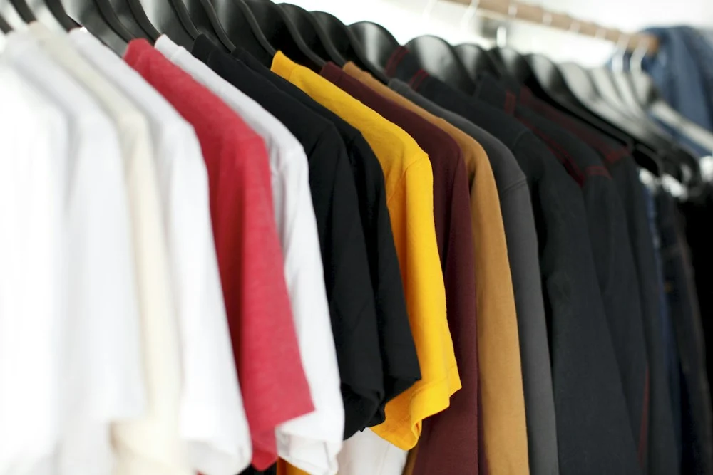 Roupas organizadas em cabides, ilustrando o cuidado com roupas e uniformes